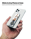 Showing the Flickstick on the back of a phone being held by a hand.